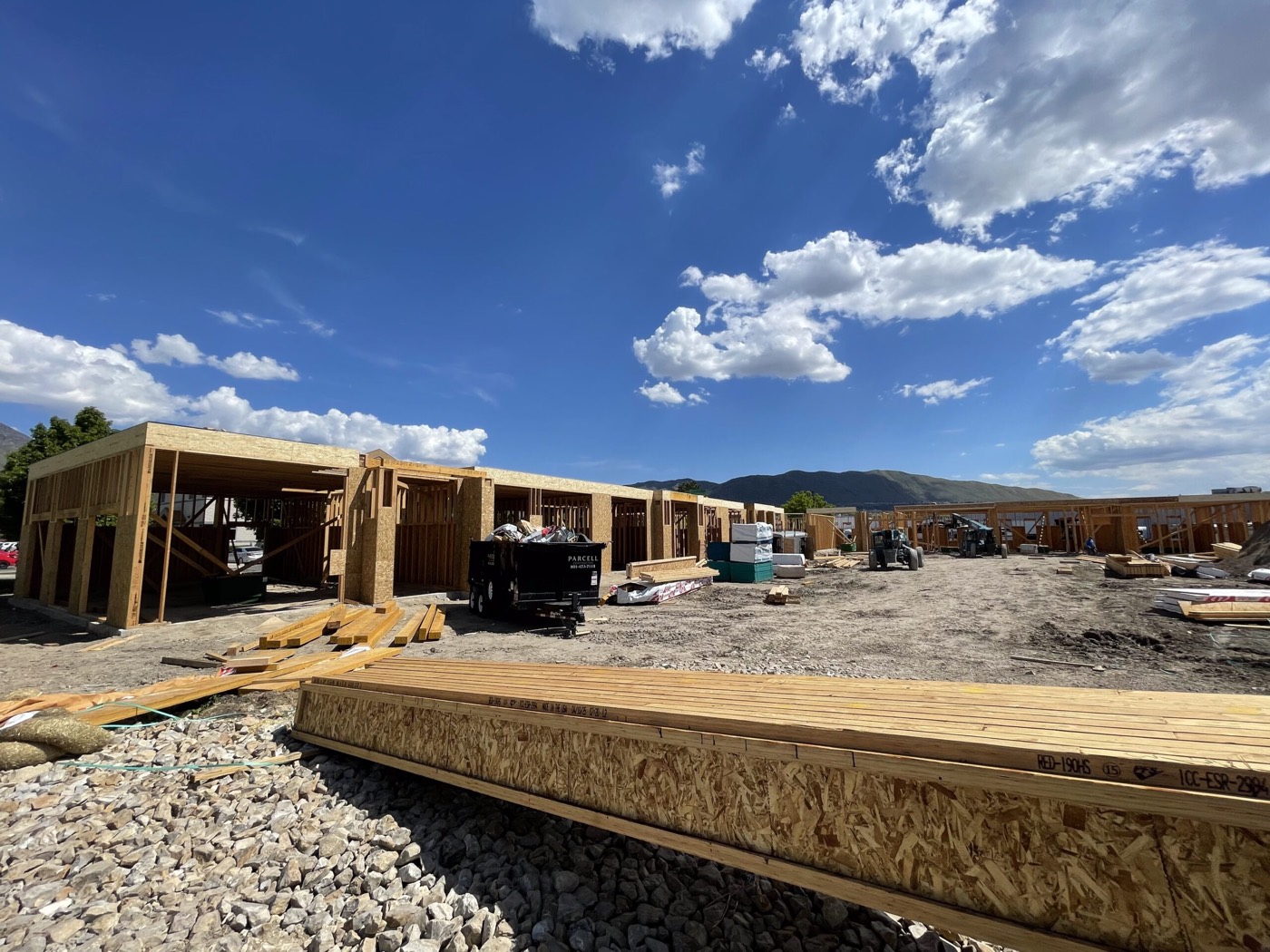 Commercial units under construction with wood framing and mountains behind